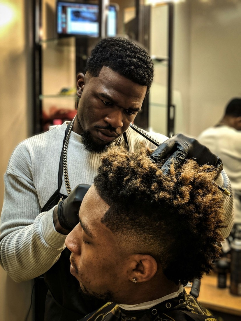 A barber giving a customer a fade
