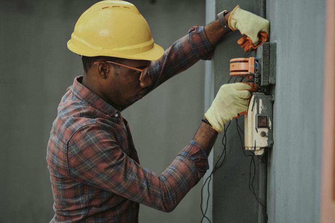 An electrician wiring a wall unit