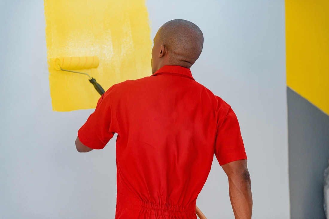 A painter rolling a wall